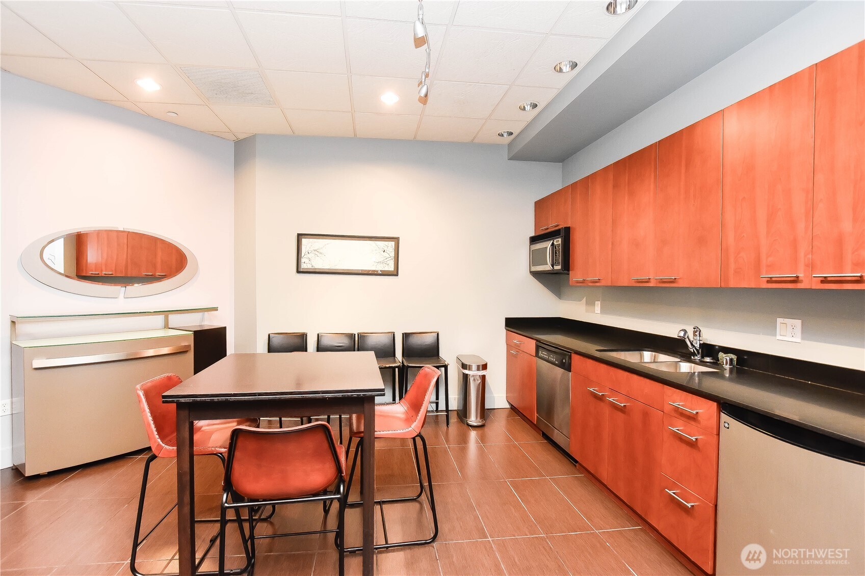 159 Denny Way, Unit 402 Seattle, WA 98109 - Photo 14 of 23 a kitchen with stainless steel appliances granite countertop a table chairs sink and cabinets