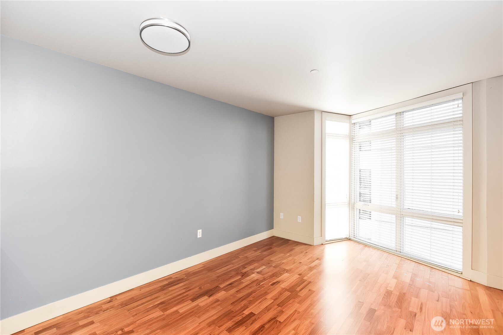 159 Denny Way, Unit 402 Seattle, WA 98109 - Photo 8 of 23 a view of an empty room with wooden floor and a window