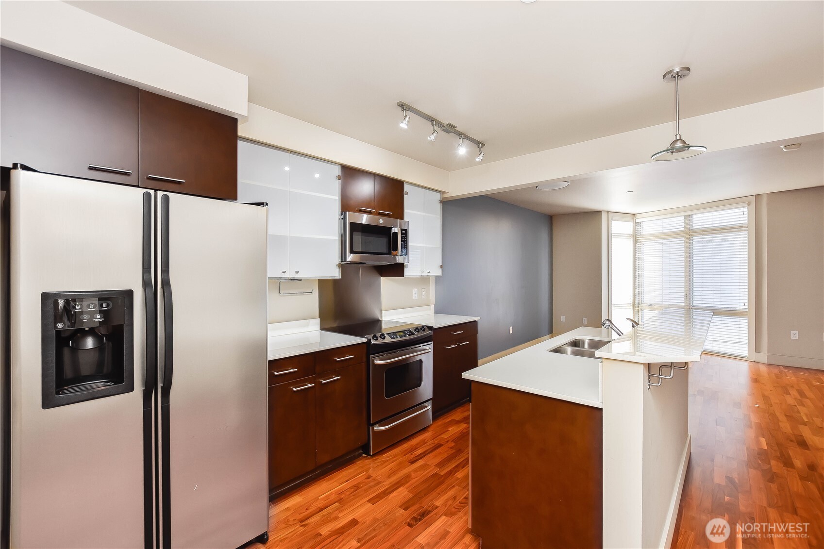 159 Denny Way, Unit 402 Seattle, WA 98109 - Photo 9 of 23 a kitchen with kitchen island a counter top space stainless steel appliances and cabinets