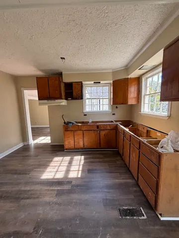 a large kitchen with stainless steel appliances granite countertop a sink and a stove top oven