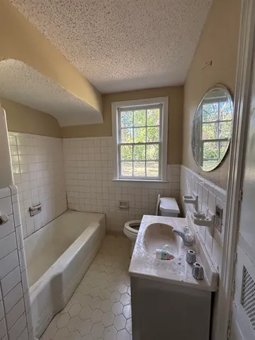 a en suite bathroom with a tub sink and mirror