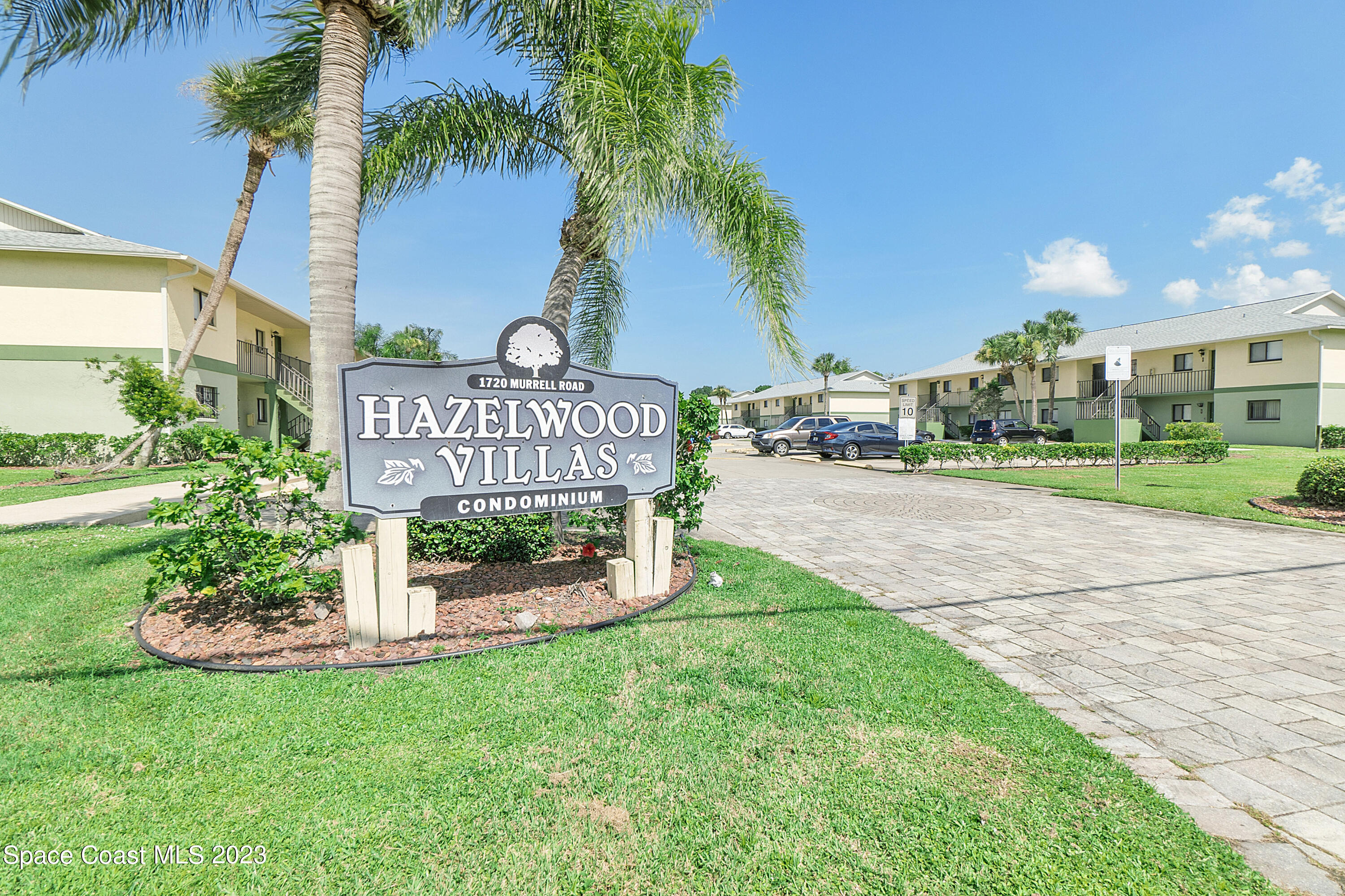 1720 Murrell Road, Unit 203 Rockledge, FL 32955 - Photo 2 of 13 a sign board with flower garden and wooden fence