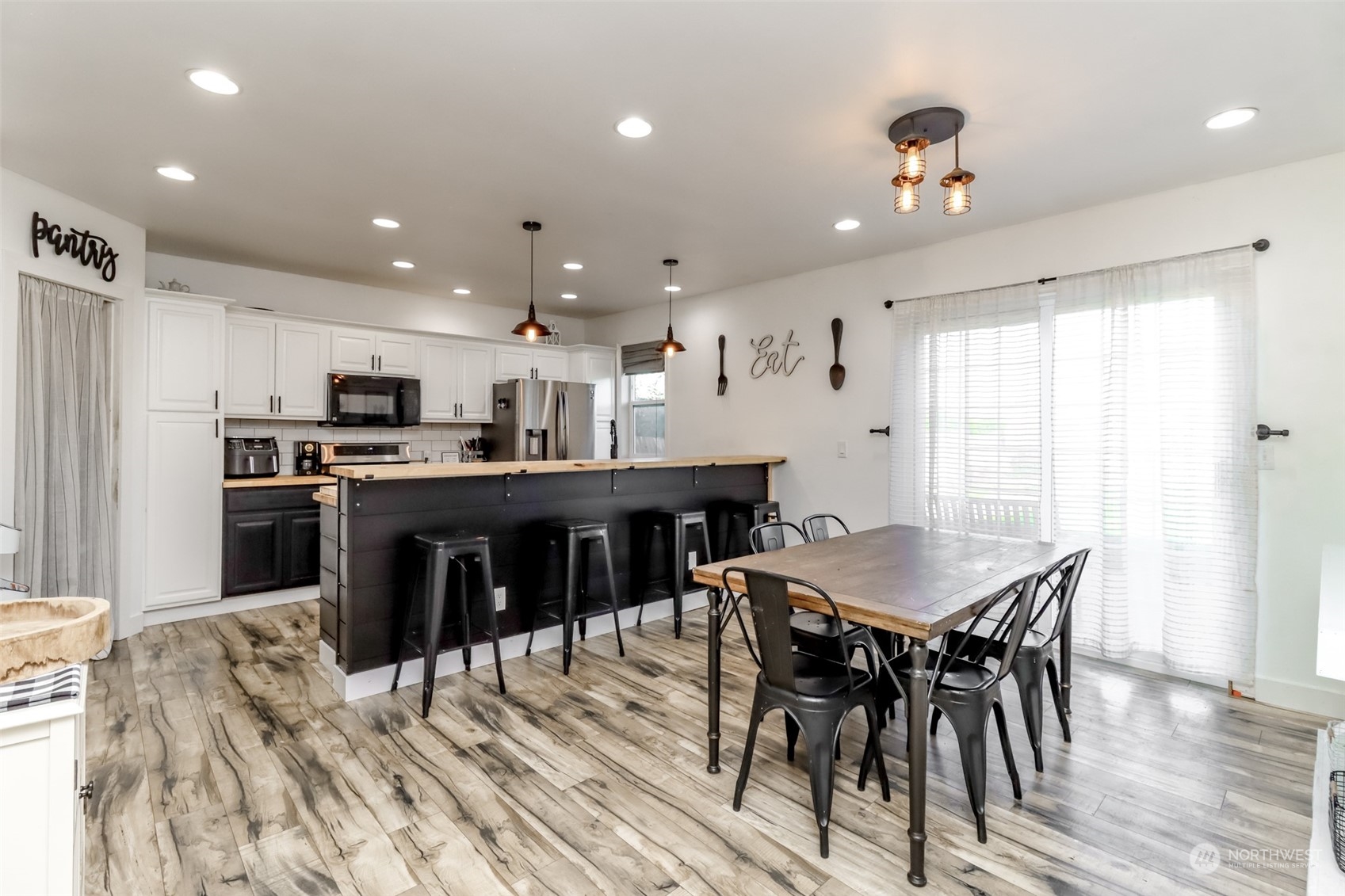 1355 McHugh Avenue Enumclaw, WA 98022 - Photo 9 of 35 a kitchen with stainless steel appliances kitchen island granite countertop a sink a stove a dining table and chairs