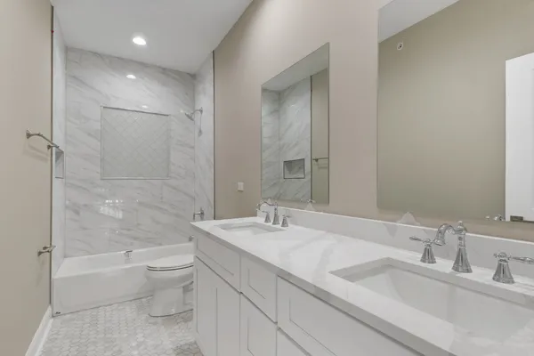 a bathroom with a granite countertop sink a toilet and bathtub