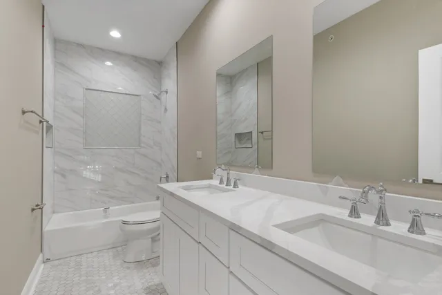 a bathroom with a granite countertop sink a toilet and bathtub