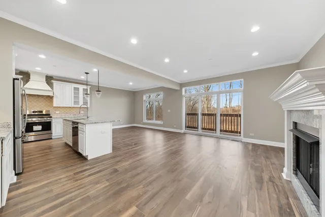 an open kitchen with white cabinets wooden floor and stainless steel appliances