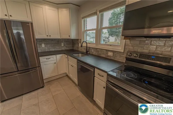 a kitchen with stainless steel appliances a refrigerator sink and cabinets