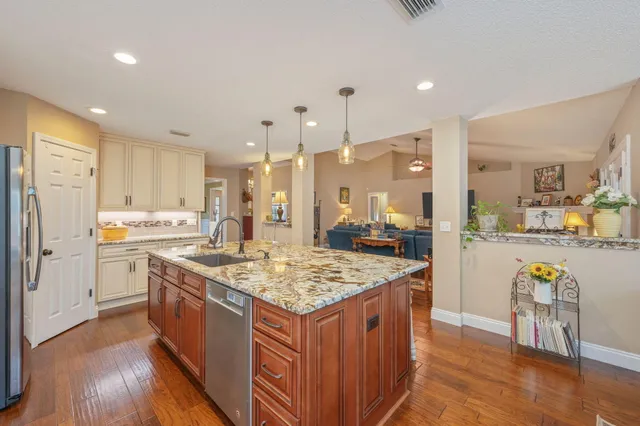 a kitchen with stainless steel appliances granite countertop counter top space stove refrigerator and cabinets