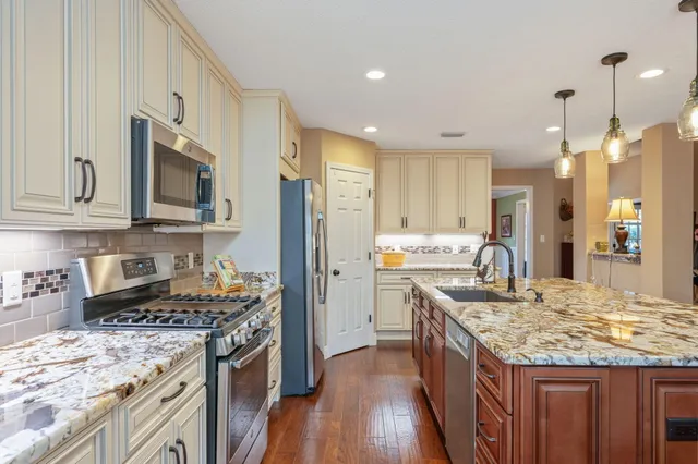 a kitchen with granite countertop a sink stove and refrigerator