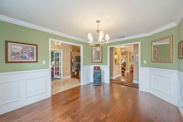 a view of a hallway with wooden floor windows and a chandelier