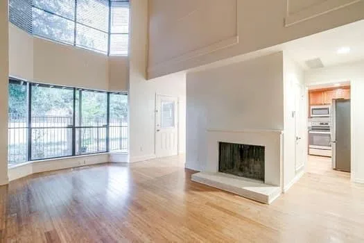 a view of a livingroom with a fireplace wooden floor and window