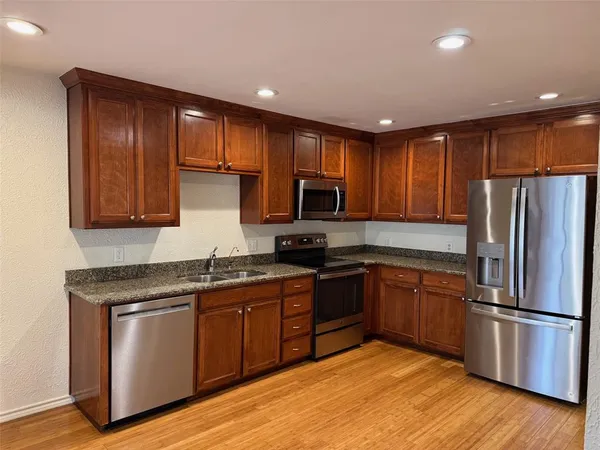 a kitchen with wooden cabinets stainless steel appliances and a sink