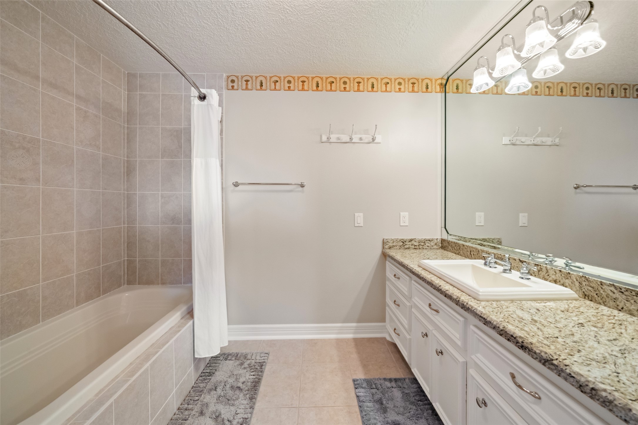 12200 Pebble View Drive Conroe, TX 77304 - Photo 28 of 43 a bathroom with a granite countertop sink a mirror and a bathtub