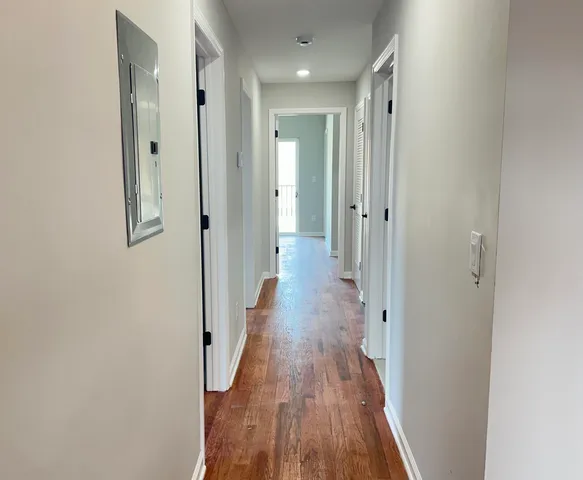 a view of a hallway with wooden floor