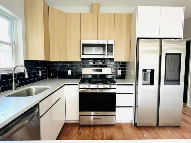 a kitchen with stainless steel appliances granite countertop a stove a sink and a refrigerator