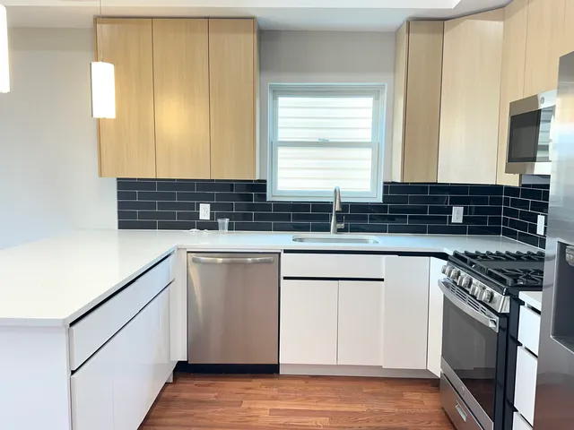 a kitchen with stainless steel appliances granite countertop a sink stove and cabinets