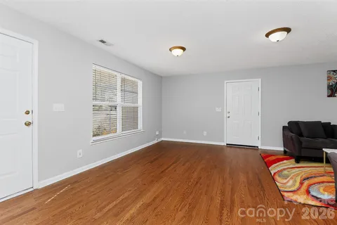 a view of a livingroom with wooden floor and furniture