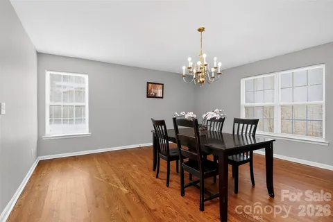 a dining room with furniture a chandelier and wooden floor