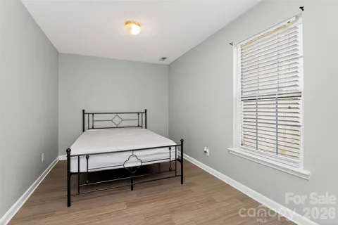 a bed sitting in a bedroom next to a window