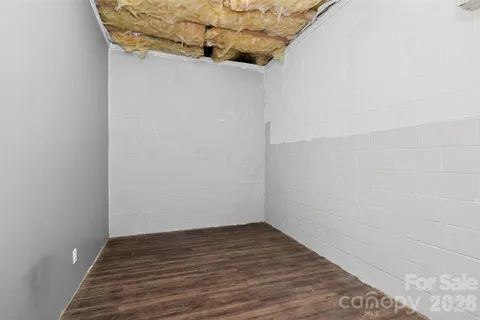 a view of a small space with wooden floor and a window