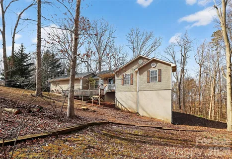 a view of a white house with a yard covered by side of the road