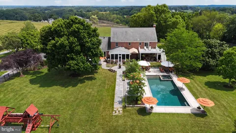an aerial view of residential houses with outdoor space and lake view
