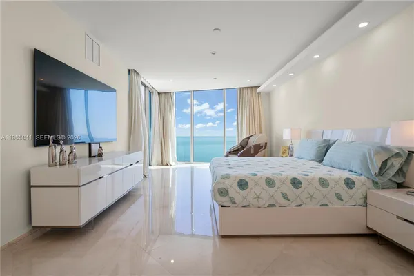 a spacious bedroom with a large bed and a flat screen tv