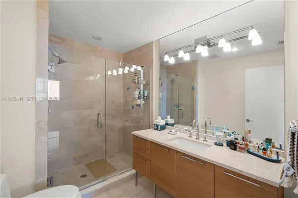 a bathroom with a sink mirror and shower
