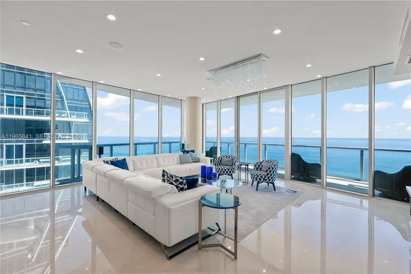 a living room with furniture and floor to ceiling windows