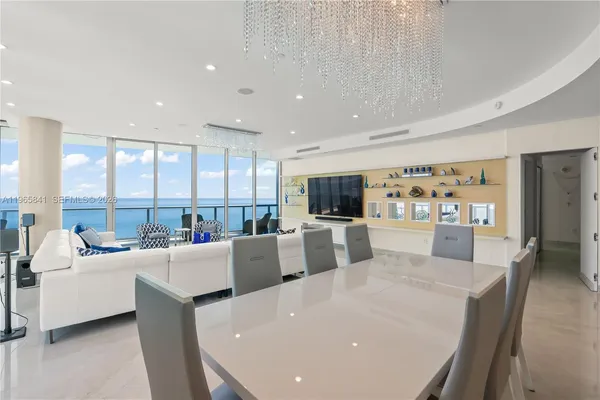 a large white kitchen with a large window and white table