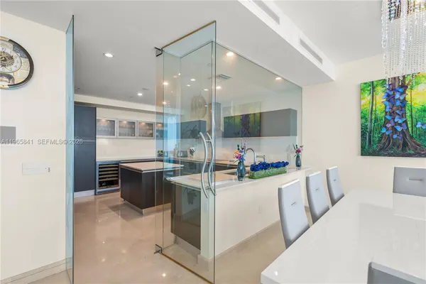 a living room with stainless steel appliances furniture a rug and a painting