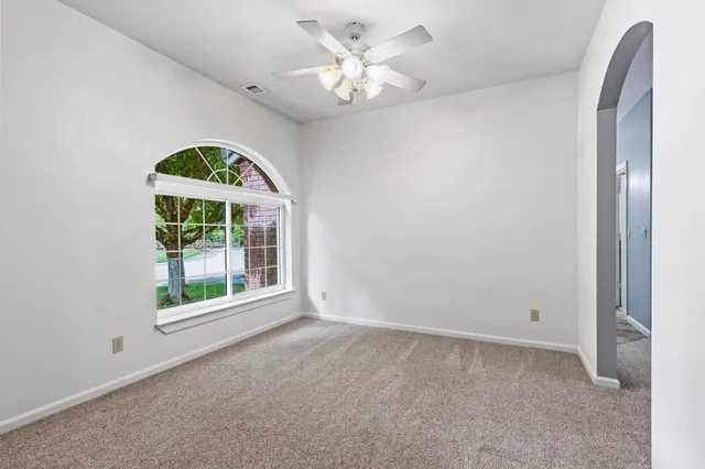 a view of an empty room with a ceiling fan