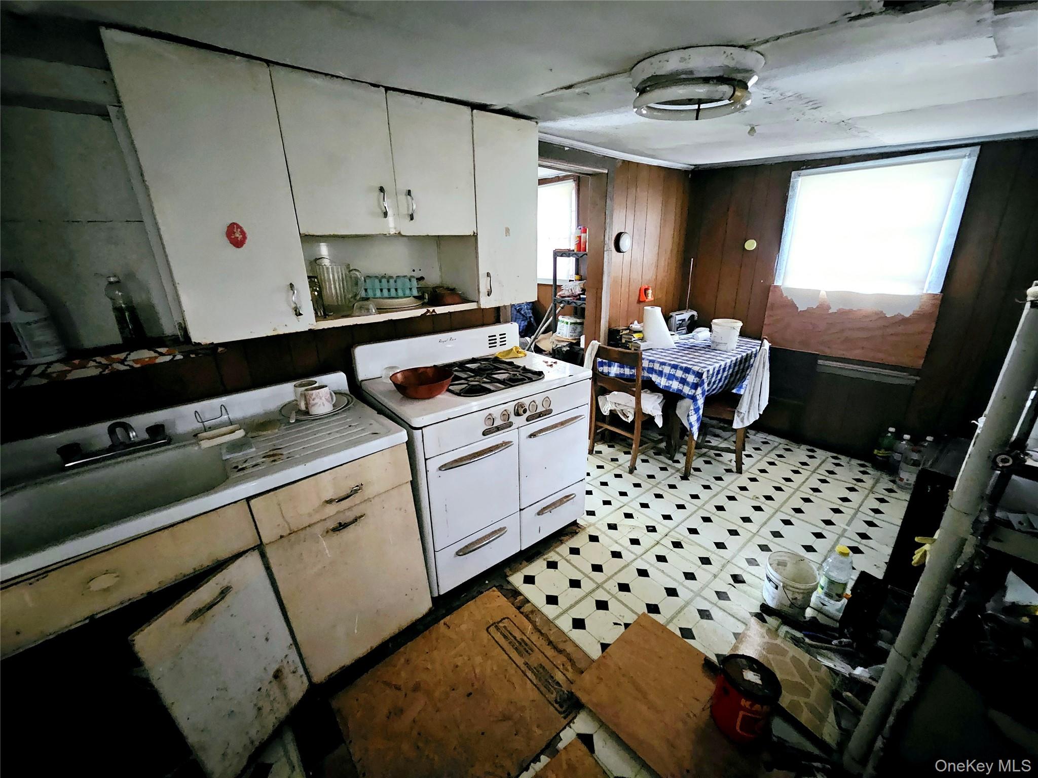 549 Granny Road Medford, NY 11763 - Photo 12 of 37 a kitchen with a sink a stove a window and white cabinets