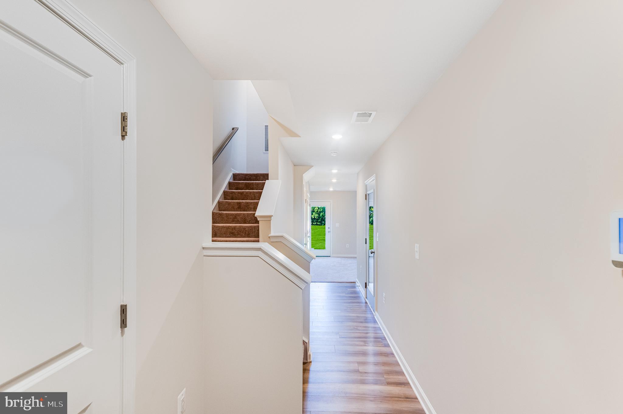 133 Gray Silver Road, Unit LANCASTER Inwood, WV 25428 - Photo 9 of 22 a view of a hallway with wooden floor and stairs