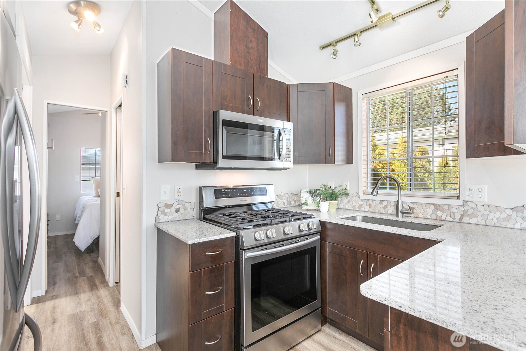 4751 Birch Bay Lynden Road, Unit 129 Blaine, WA 98230 - Photo 14 of 34 a kitchen with stainless steel appliances granite countertop a stove a sink and a microwave