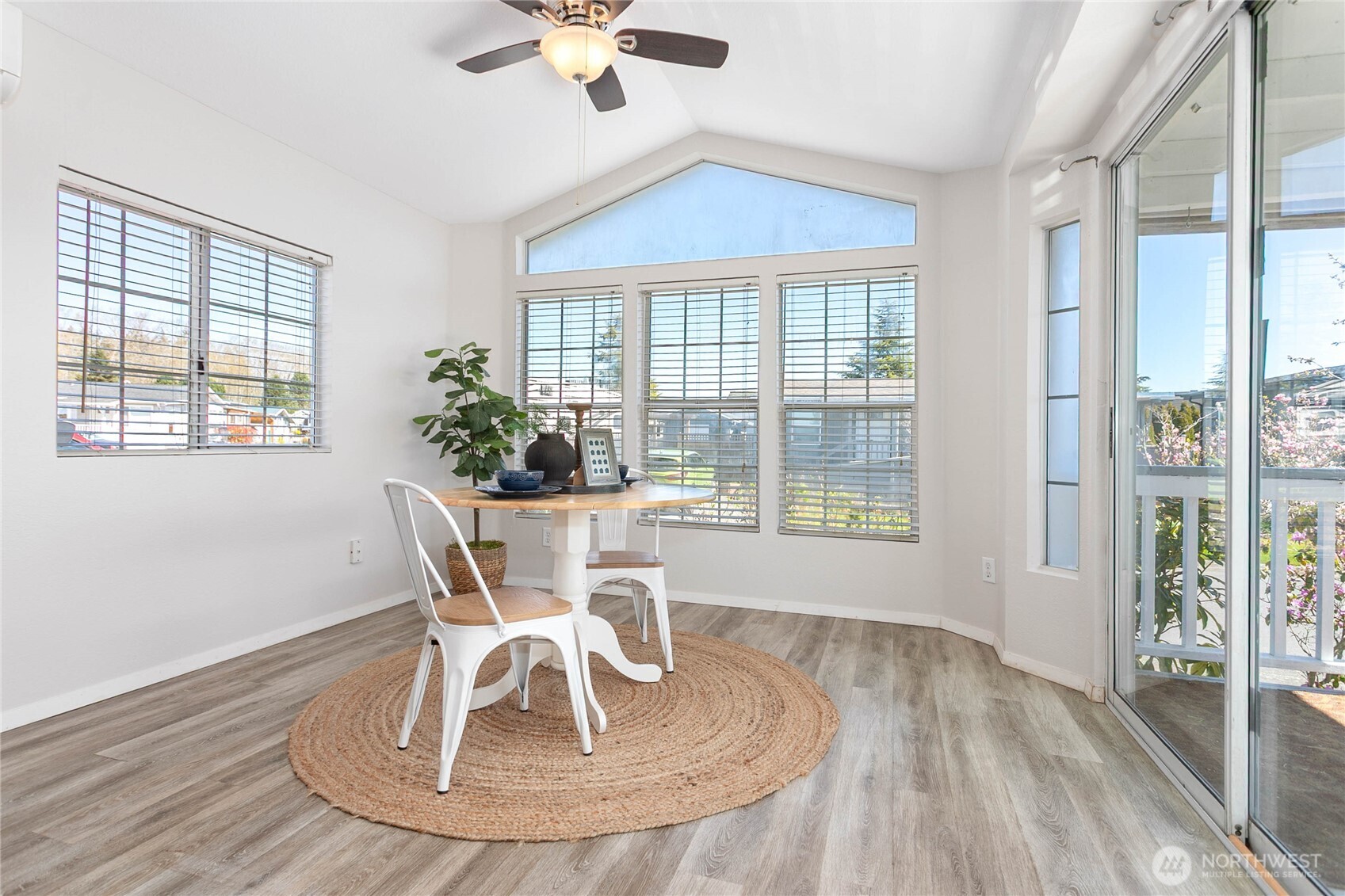 4751 Birch Bay Lynden Road, Unit 129 Blaine, WA 98230 - Photo 18 of 34 a dining room with wooden floor a chandelier a glass table and chairs