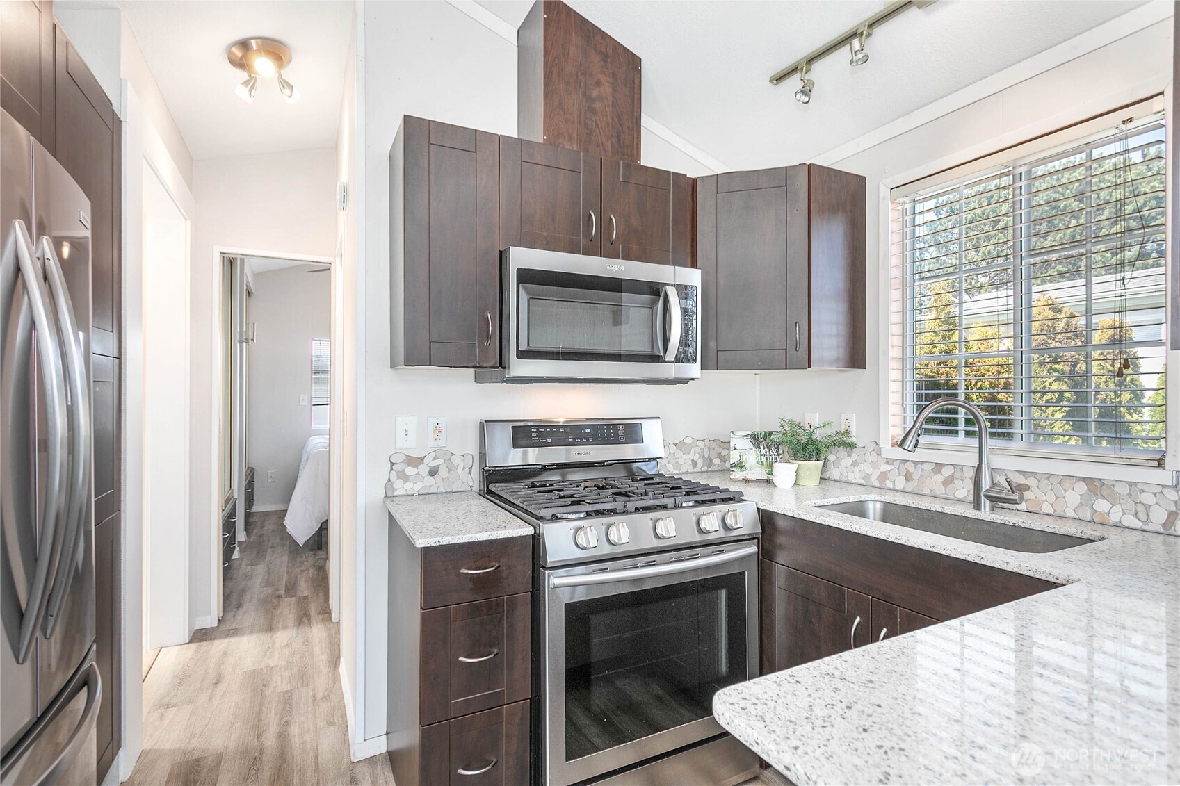 4751 Birch Bay Lynden Road, Unit 129 Blaine, WA 98230 - Photo 9 of 34 a kitchen with stainless steel appliances granite countertop a stove a sink and a microwave