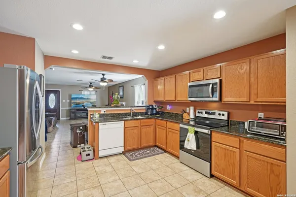 a kitchen with stainless steel appliances granite countertop a refrigerator and a stove top oven