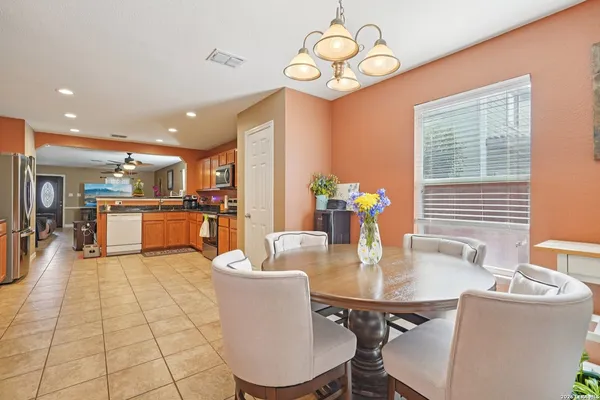 a dining room filled chandelier and kitchen view
