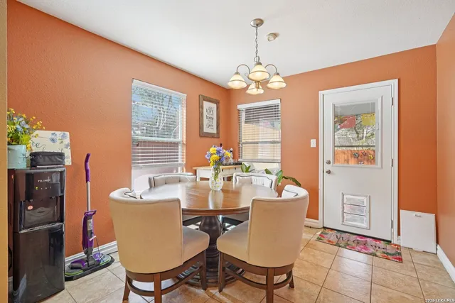 a view of a dining room with furniture a chandelier and wooden floor