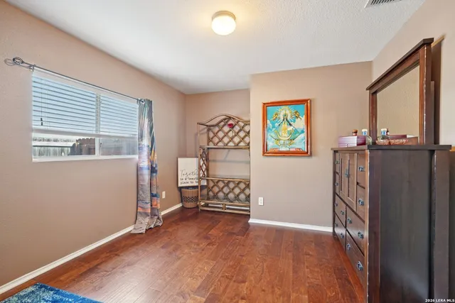 a view of an empty room with window and wooden floor