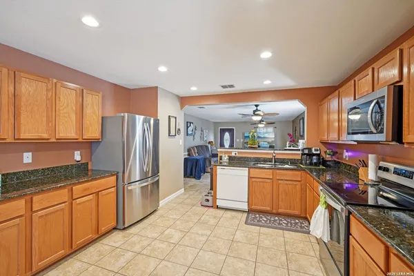 a kitchen with stainless steel appliances granite countertop a refrigerator and a stove top oven