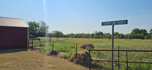 a view of outdoor space with green field and trees