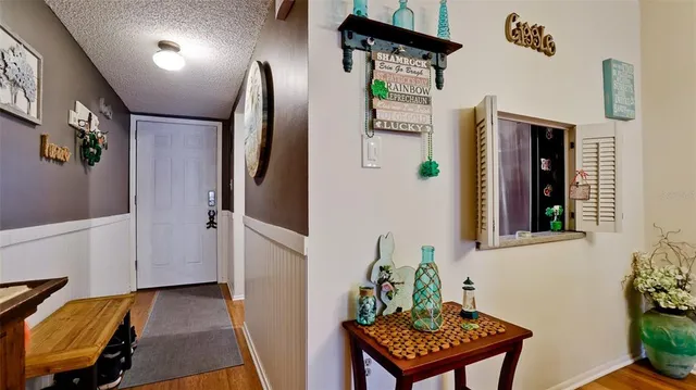 a view of a hallway to a livingroom with furniture and a window