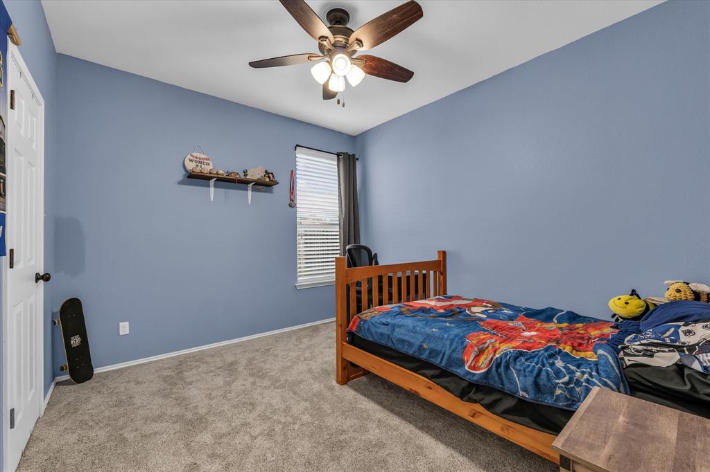 9453 Centennial Drive Waco, TX 76708 - Photo 6 of 37 a bedroom with a bed and a chandelier