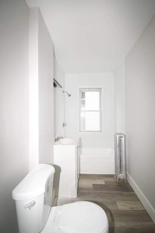 72 Malden Street Springfield, MA 01108 - Photo 17 of 25 a white toilet sitting next to a bathroom sink and vanity