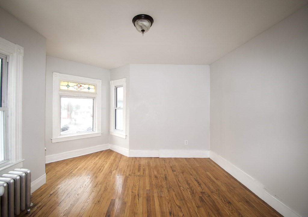 72 Malden Street Springfield, MA 01108 - Photo 22 of 25 an empty room with wooden floor and windows