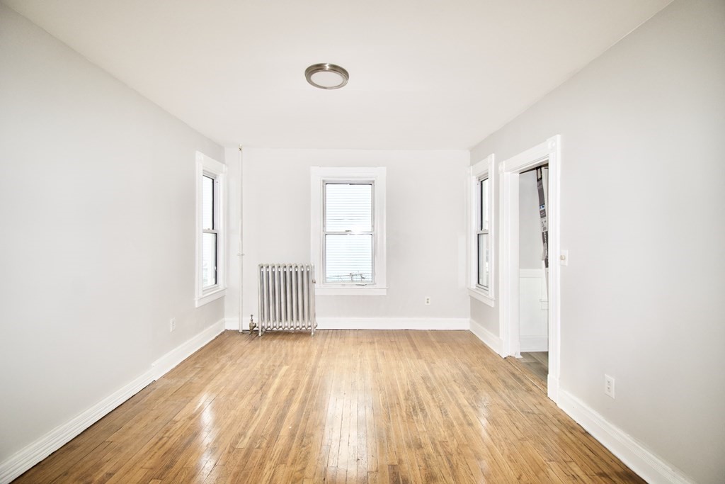 72 Malden Street Springfield, MA 01108 - Photo 8 of 25 an empty room with wooden floor and windows