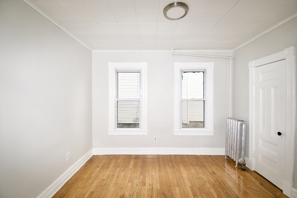 72 Malden Street Springfield, MA 01108 - Photo 9 of 25 an empty room with wooden floor and windows