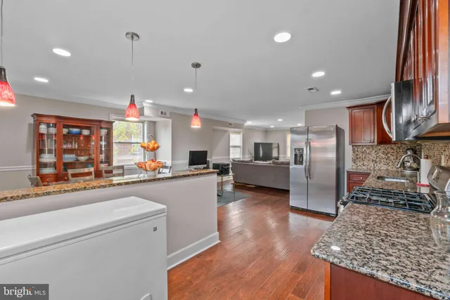 a open kitchen with stainless steel appliances granite countertop a refrigerator and stove